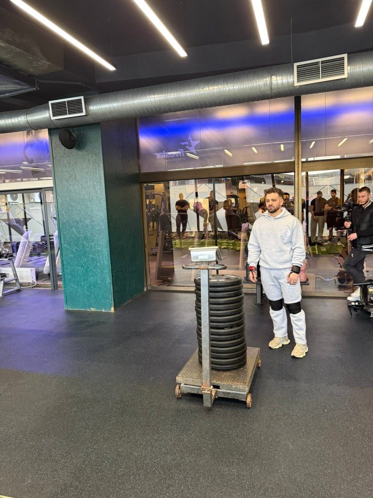 Muškarac pored gomile tegova na platformi.